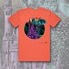 Salmon colored t-shirt with a circle on the chest. Circle contains a purple castle, blue bats & green landscape in the background. 